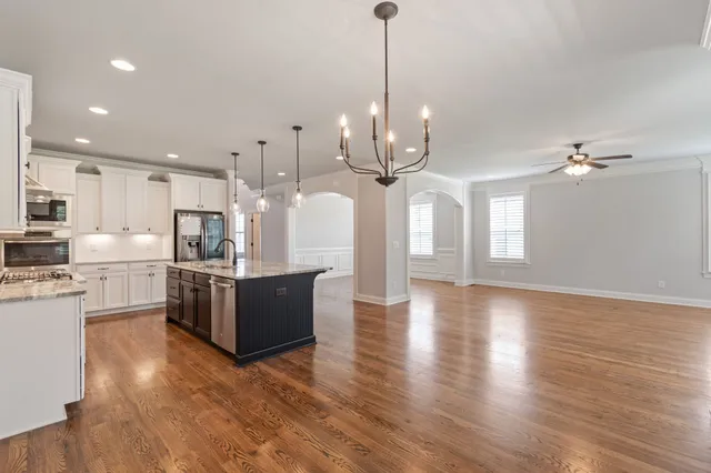 a view of an empty room with wooden floor fireplace and a window