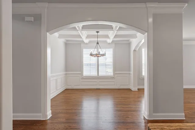 a kitchen with stainless steel appliances granite countertop a sink a stove a refrigerator and island with wooden floor