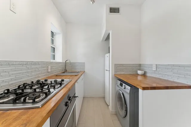 a kitchen with granite countertop white cabinets and a sink