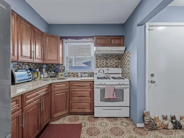 a kitchen with stainless steel appliances granite countertop a stove a sink and a refrigerator