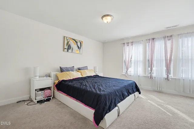 a spacious bedroom with a bed and a window