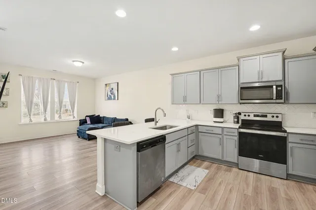 a kitchen with stainless steel appliances kitchen island granite countertop a sink and stove top oven