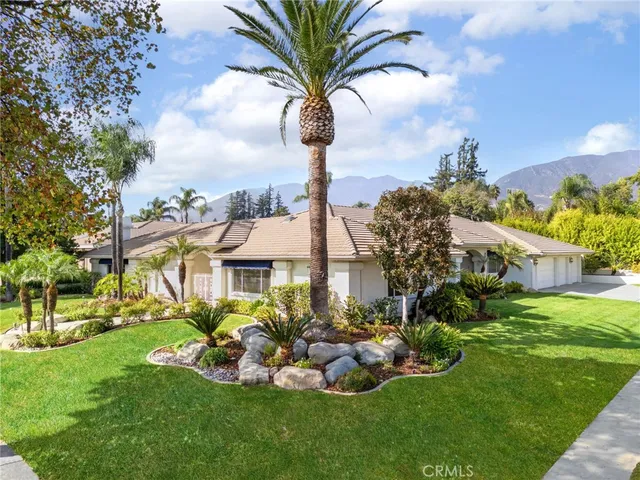 a front view of a house with a garden and trees