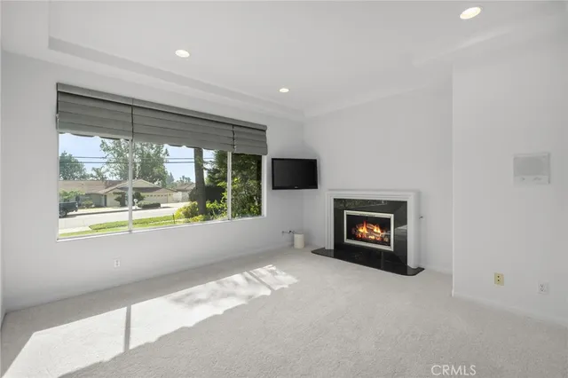 an empty room with windows and fireplace