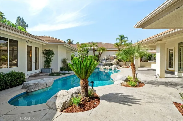 a view of a house with swimming pool and sitting area