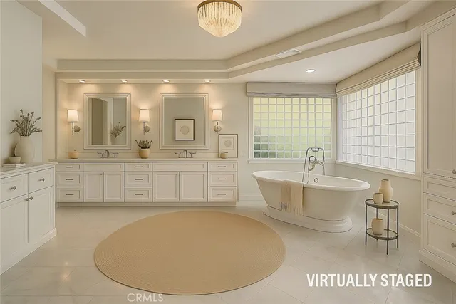 a spacious bathroom with a tub sink and mirror