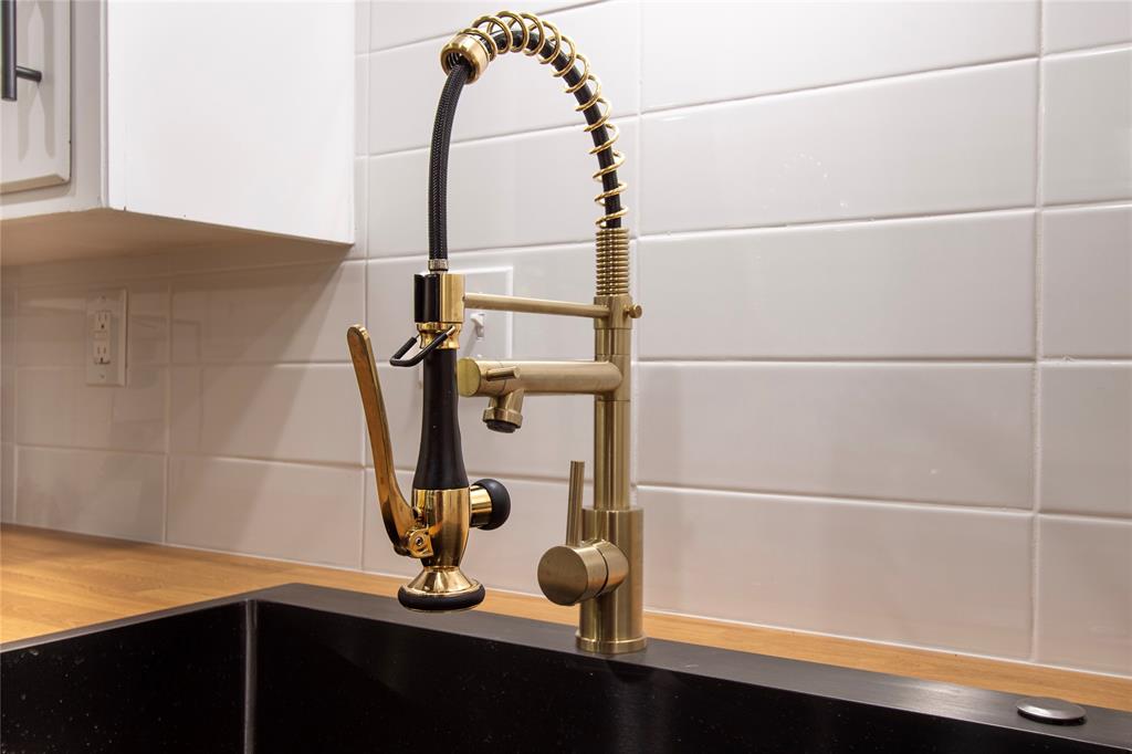 1205 Augusta Road Benbrook, TX 76126 - Photo 10 of 21 Gold-tone kitchen faucet with a pull-down sprayer, set against a white subway tile backsplash