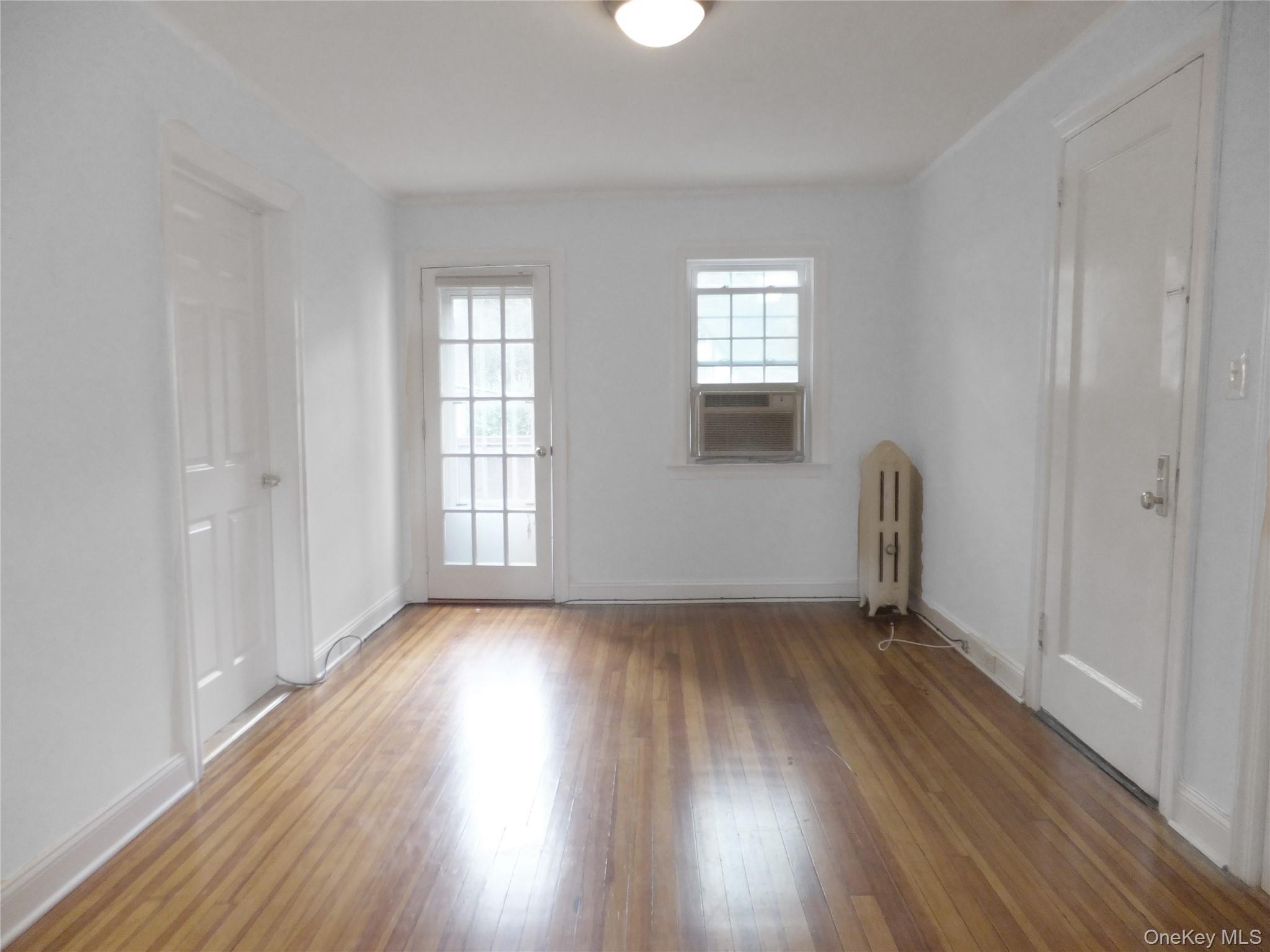 107 Kensington Road, Unit 5 Bronxville, NY 10708 - Photo 7 of 17 Unfurnished room with hardwood / wood-style floors, radiator heating unit, and cooling unit