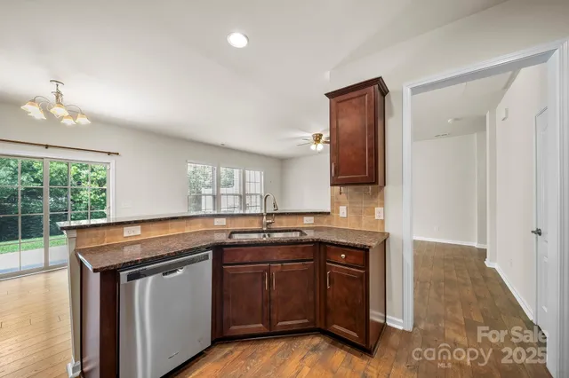 a kitchen with granite countertop a sink stove and cabinets