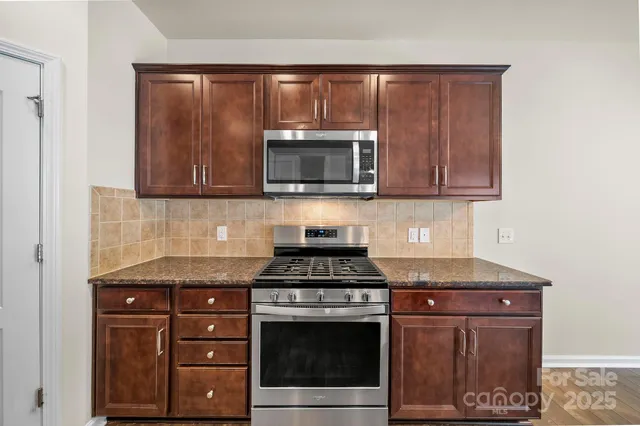 a kitchen with granite countertop a stove and a microwave