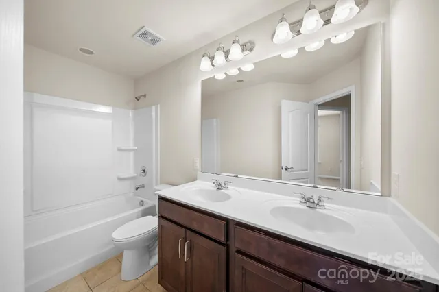 a bathroom with a sink a toilet and a large mirror
