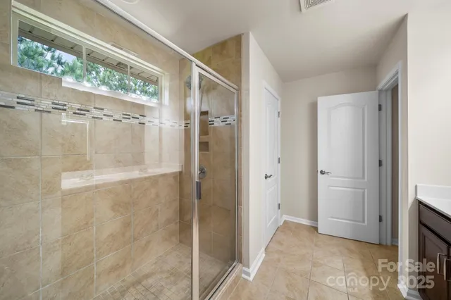a bathroom with a double vanity sink mirror and shower
