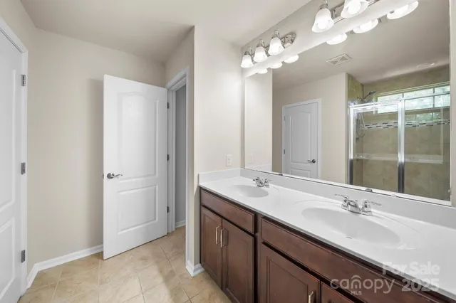 a bathroom with a double vanity sink mirror and shower