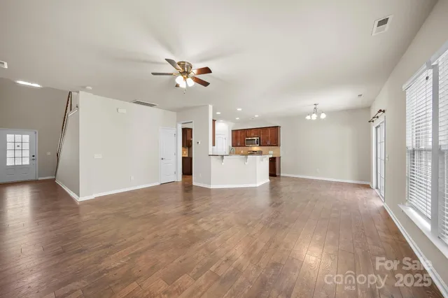a view of empty room with wooden floor and window