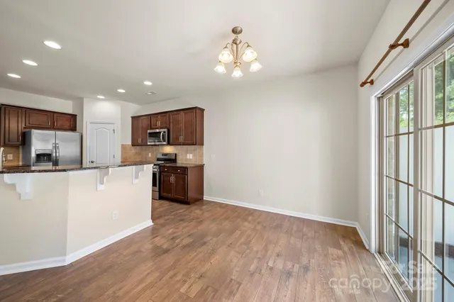 a large kitchen with cabinets wooden floor and stainless steel appliances