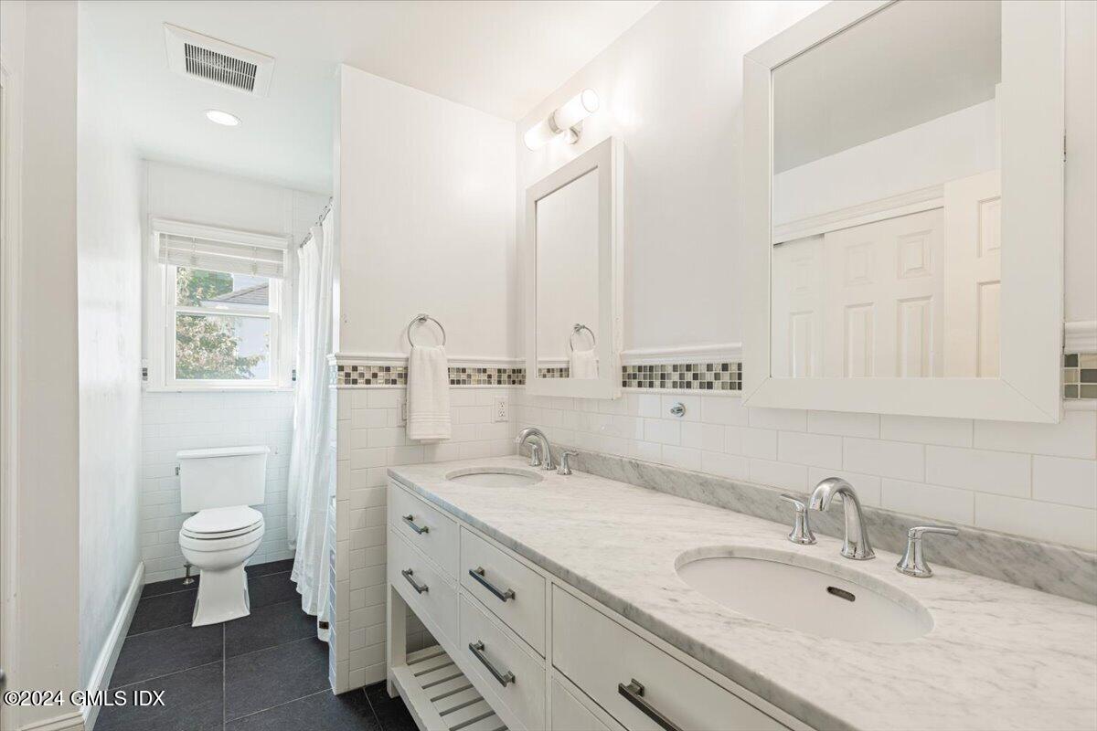70 Gregory Road Cos Cob, CT 06807 - Photo 20 of 39 a bathroom with a granite countertop sink mirror vanity and a toilet