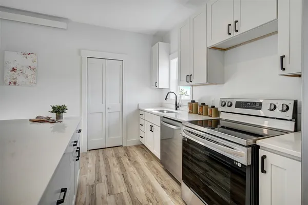 a kitchen with stainless steel appliances a sink stove and cabinets