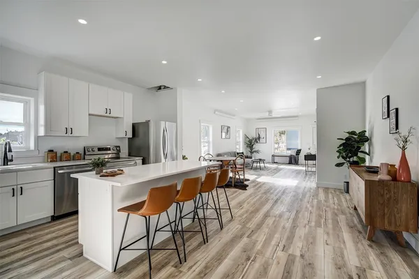 a view of a kitchen with cabinets stainless steel appliances and a dining table