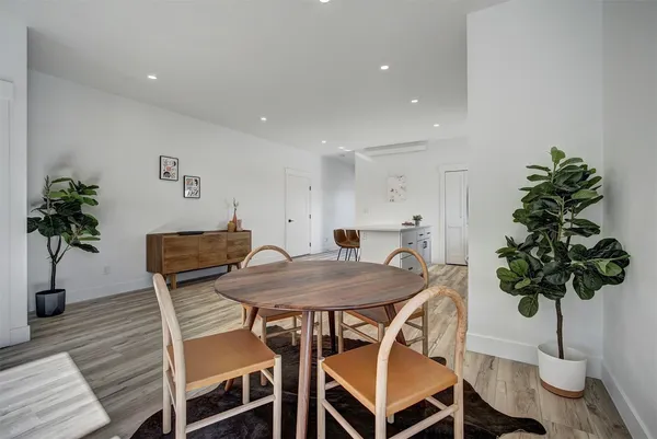 a kitchen with stainless steel appliances a refrigerator a stove a sink and white cabinets with wooden floor