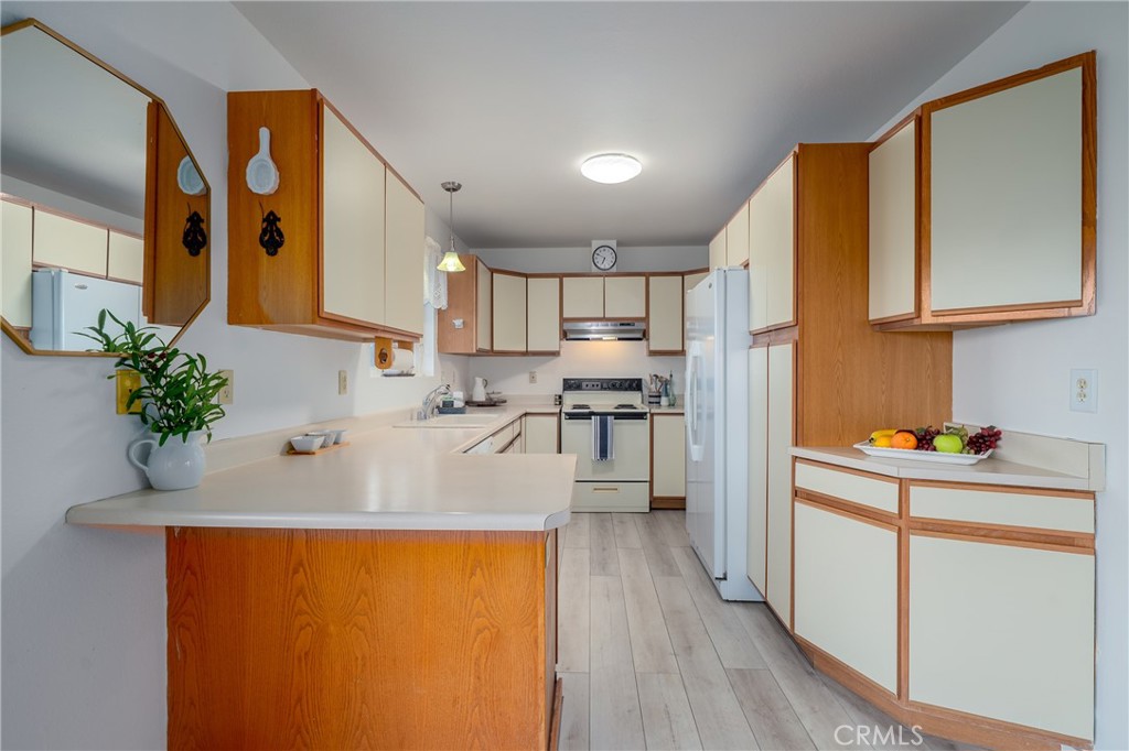 4777 Hawaina Way Kelseyville, CA 95451 - Photo 17 of 48 a kitchen with stainless steel appliances granite countertop a refrigerator a sink dishwasher and white cabinets with wooden floor