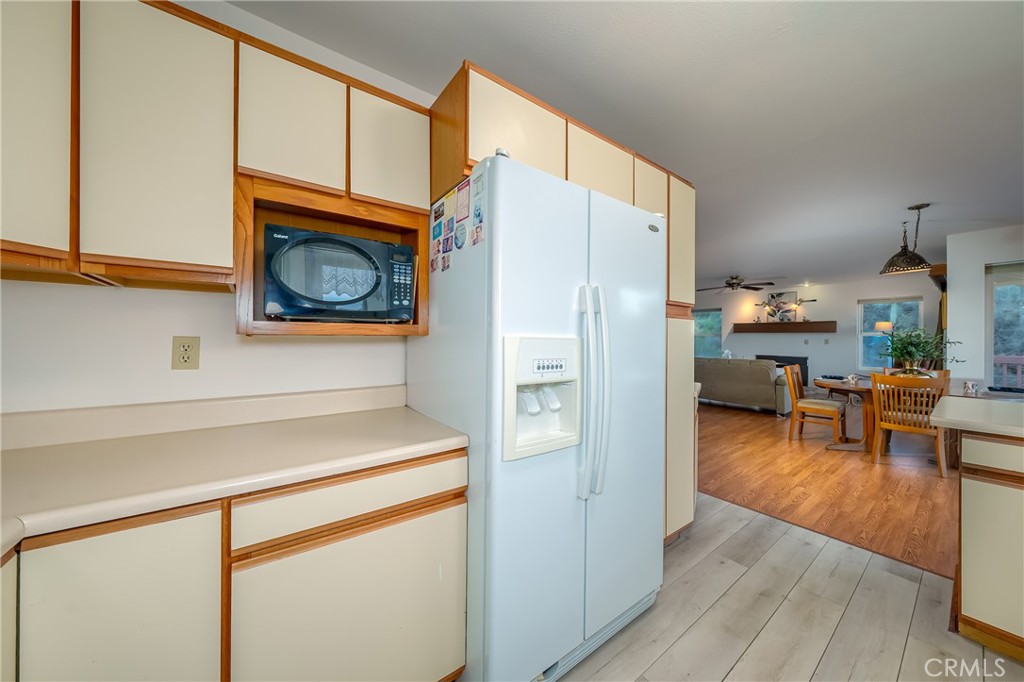 4777 Hawaina Way Kelseyville, CA 95451 - Photo 20 of 48 a kitchen view with a refrigerator a stove a dining table and chairs with wooden floor