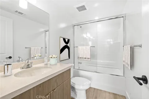 a bathroom with a sink toilet double vanity and shower