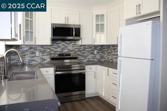 a kitchen with stainless steel appliances granite countertop a stove microwave and refrigerator