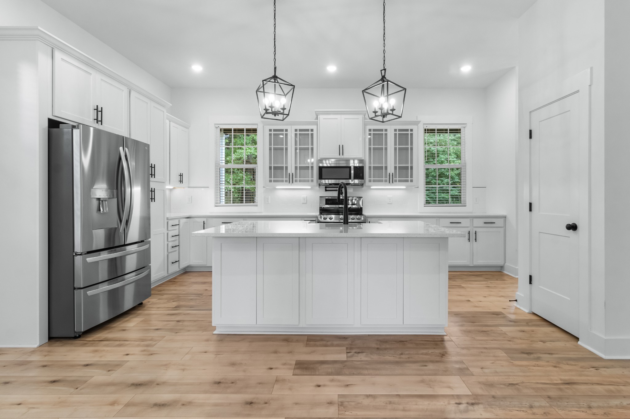 4700 Akin Road Cunningham, TN 37052 - Photo 12 of 36 a large kitchen with stainless steel appliances a large counter top a sink a refrigerator and a window