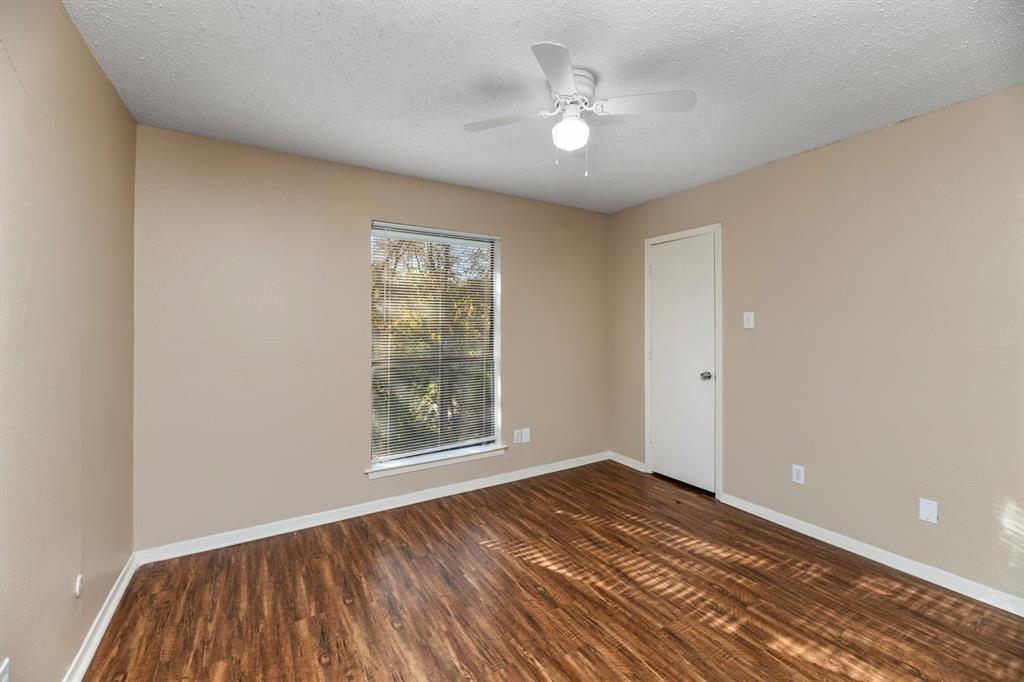 2317 Jenson Circle Fort Worth, TX 76112 - Photo 11 of 21 a view of an empty room with wooden floor and a window