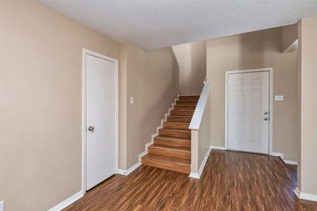 a view of a hallway with wooden floor and entryway