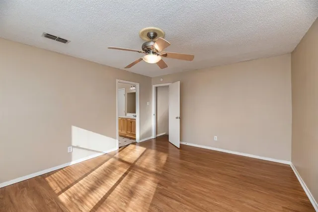 a view of a room with wooden floor and a ceiling fan