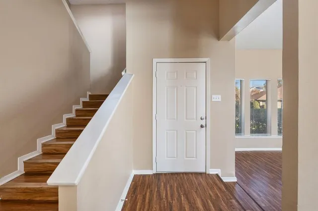 a view of a hallway with wooden floor and entryway