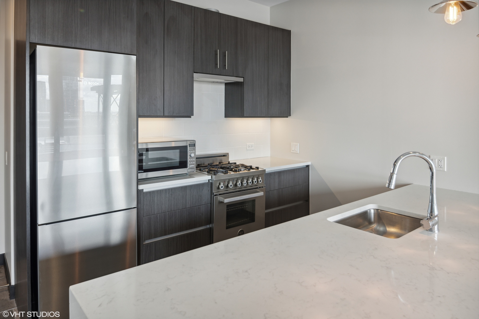 171 North Aberdeen Street, Unit 903 Chicago, IL 60607 - Photo 3 of 15 a kitchen with granite countertop a refrigerator and a sink