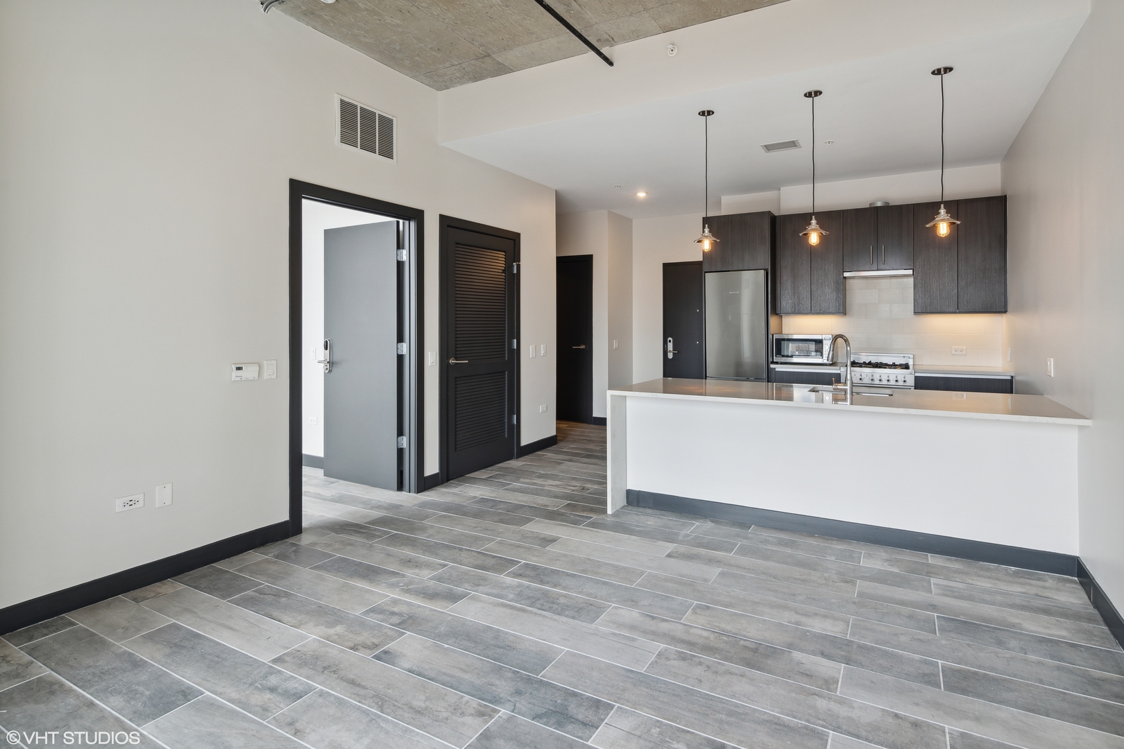 171 North Aberdeen Street, Unit 903 Chicago, IL 60607 - Photo 4 of 15 a large kitchen with stainless steel appliances a large counter top a refrigerator and a sink