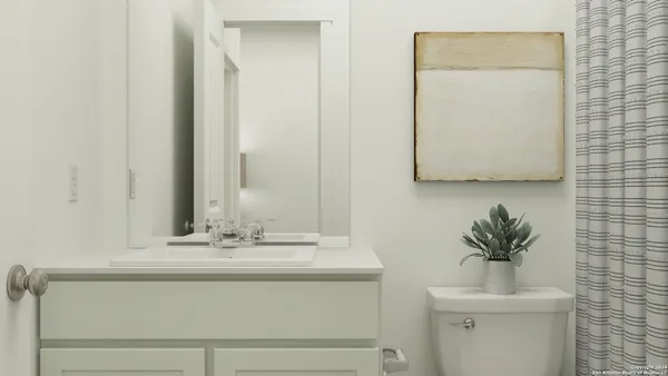 a bathroom with a sink a mirror and a potted plant