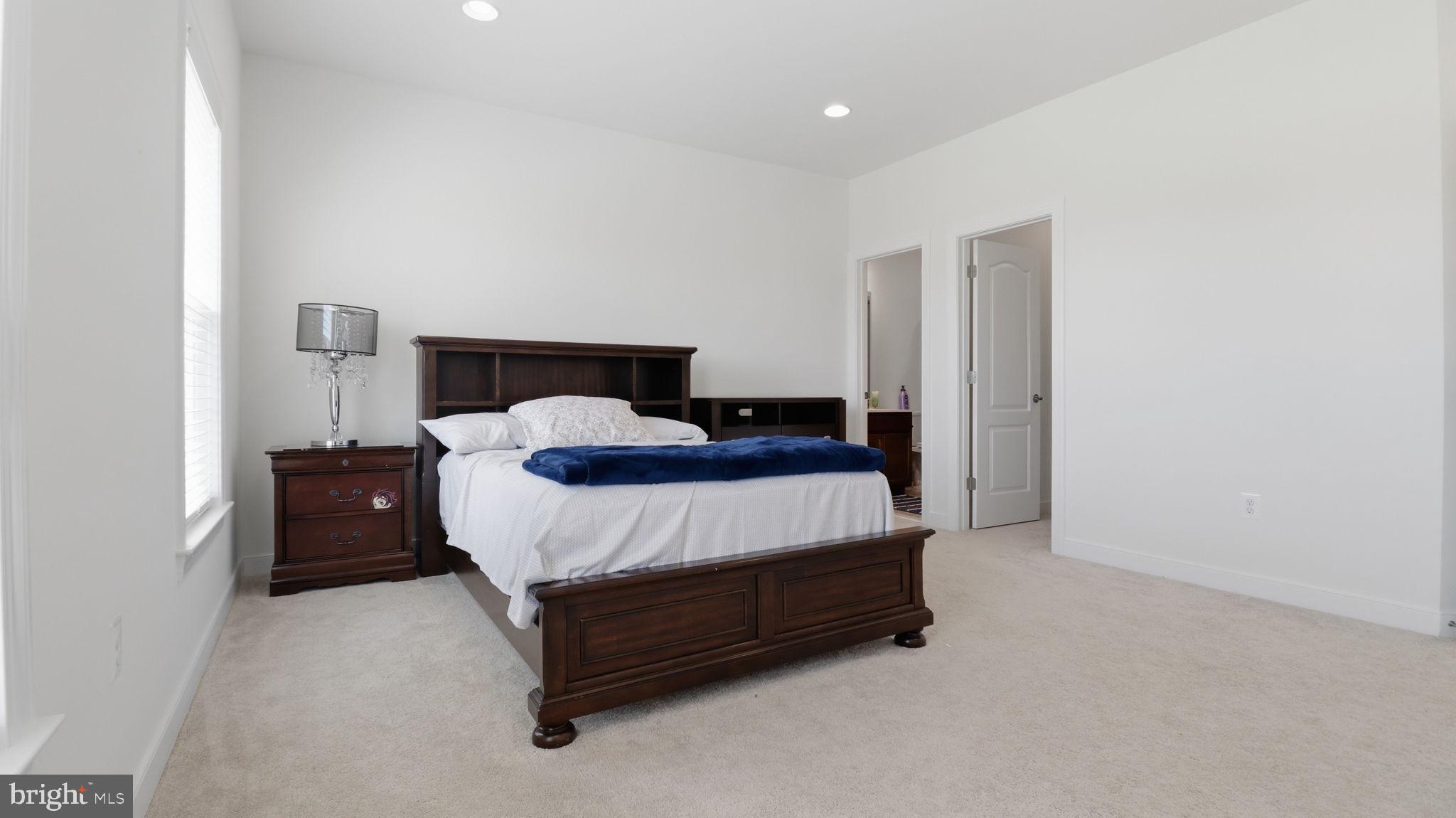 11502 Aden Road Nokesville, VA 20181 - Photo 88 of 106 a bed sitting in a bedroom next to a lamp