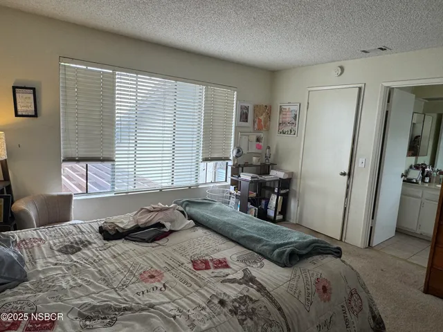 a bedroom with a bed and a large window