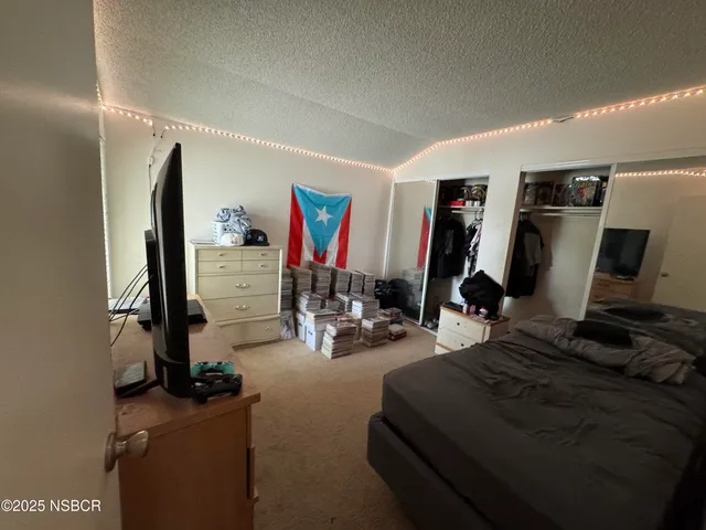 a bedroom with furniture a flat screen tv and gym equipment