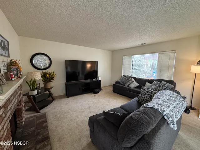 a living room with furniture a flat screen tv and a window