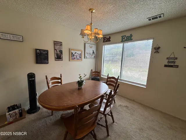 a view of a dining room with furniture and a chandelier