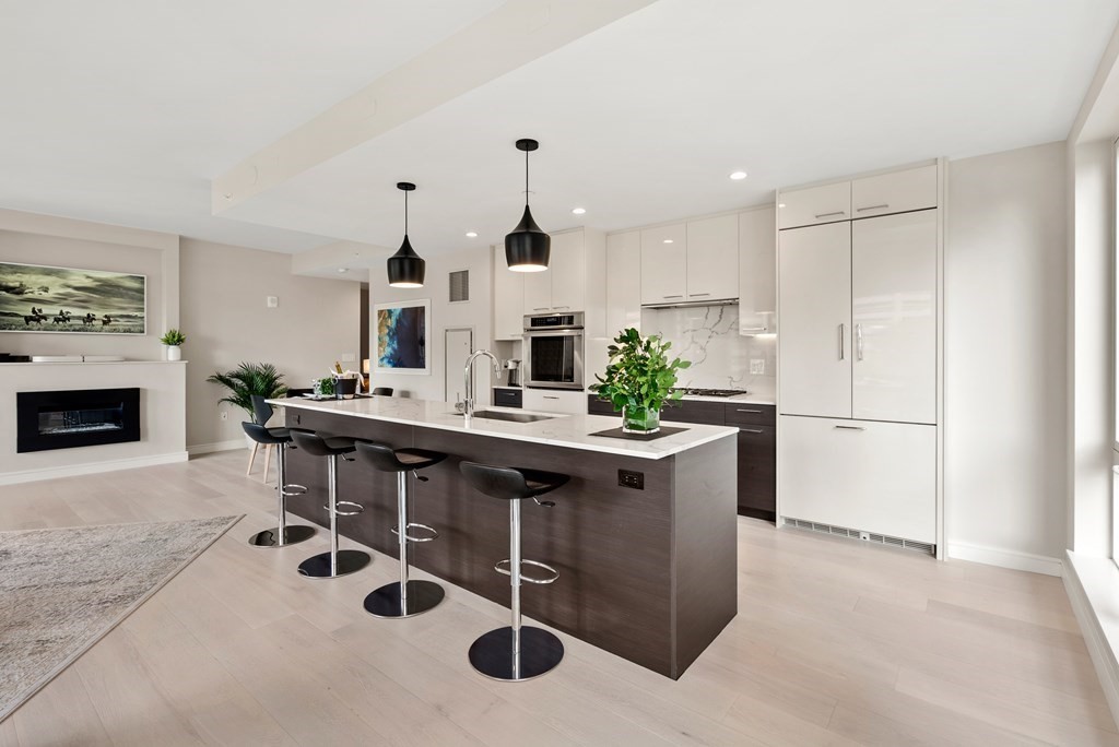 110 Broad Street, Unit 401 Boston, MA 02110 - Photo 1 of 24 a kitchen with stainless steel appliances kitchen island a table chairs in it and white cabinets