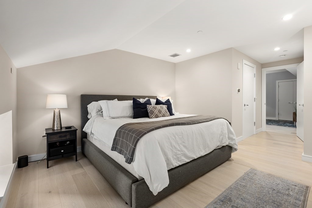 110 Broad Street, Unit 401 Boston, MA 02110 - Photo 16 of 24 a bedroom with a bed and a night stand