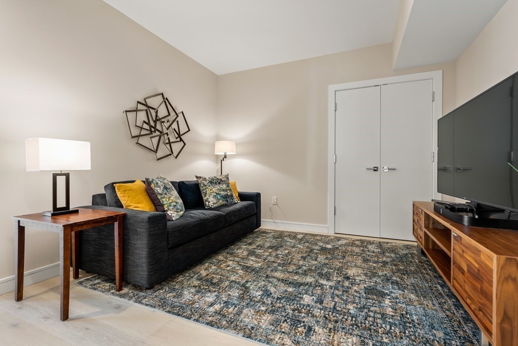 110 Broad Street, Unit 401 Boston, MA 02110 - Photo 17 of 24 a living room with furniture and a flat screen tv
