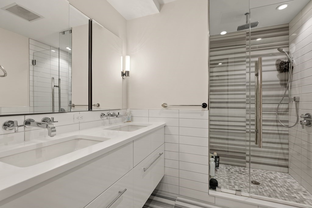 110 Broad Street, Unit 401 Boston, MA 02110 - Photo 18 of 24 a bathroom with a sink and mirror