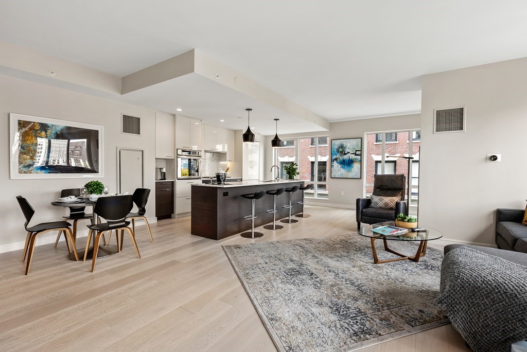 110 Broad Street, Unit 401 Boston, MA 02110 - Photo 7 of 24 a living room with furniture and kitchen view