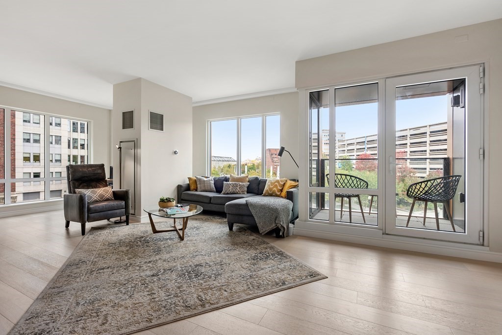 110 Broad Street, Unit 401 Boston, MA 02110 - Photo 8 of 24 a living room with furniture and large windows