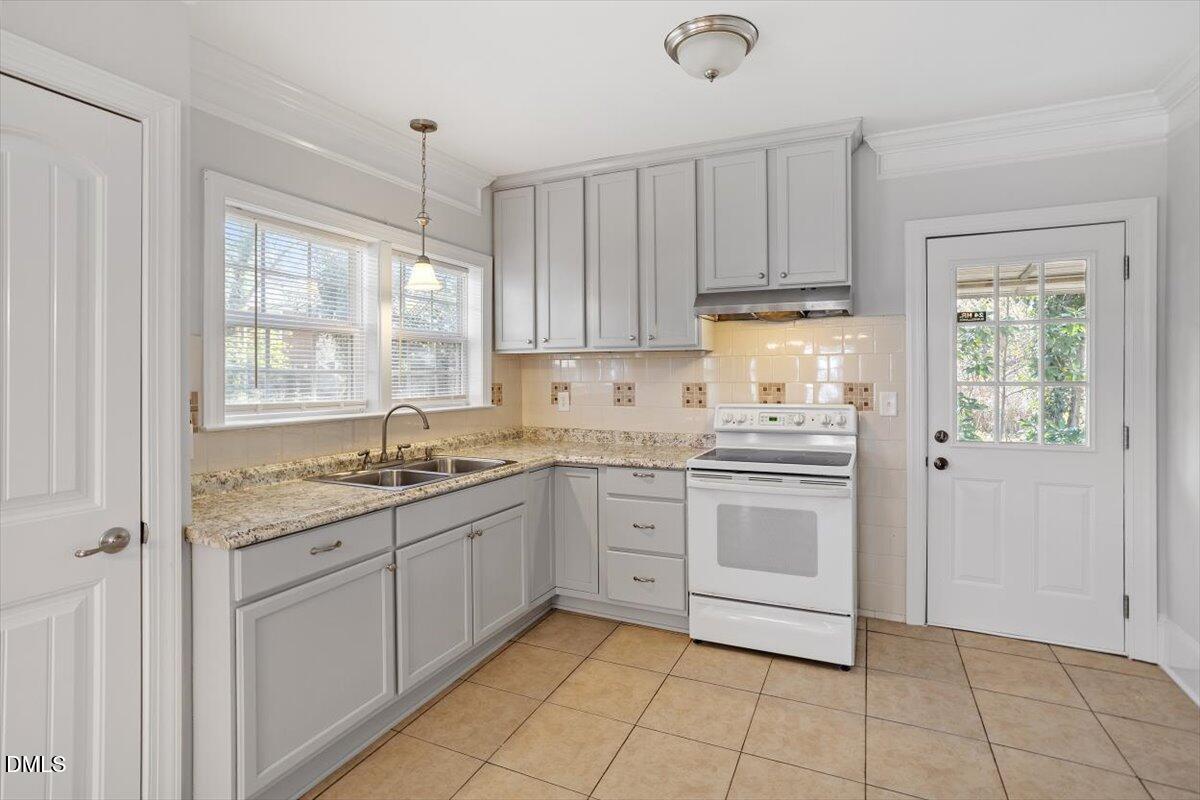 2618 Sater Street Durham, NC 27703 - Photo 12 of 27 a kitchen with granite countertop white cabinets stainless steel appliances a sink and a window