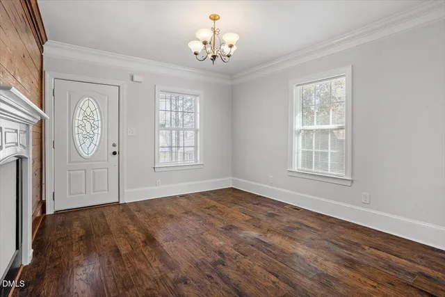 a view of empty room with wooden floor and fireplace