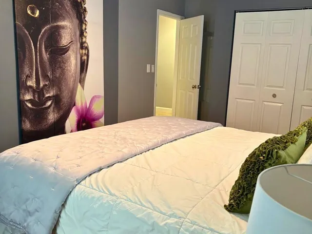 a bedroom with a bed and closet with wooden floor