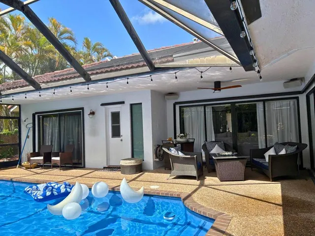 a view of a house with swimming pool and furniture